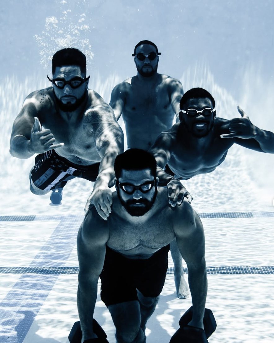 Athletes training underwater at the bottom of a pool